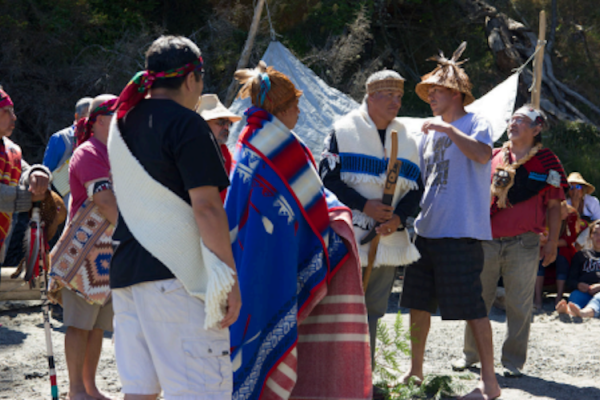 A group of individuals gather wearing traditional clothing.