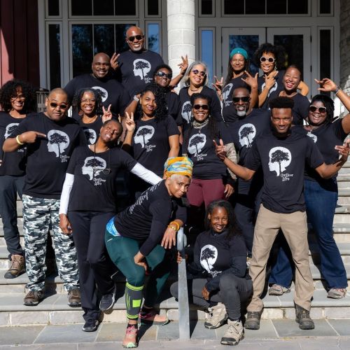 A large group of Volunteer Leaders proudly pose for a photo and wear matching black Outdoor Afro shirts at the annual Leadership Training event.