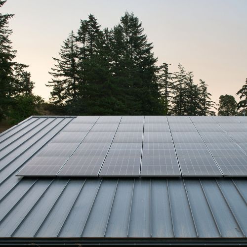 Close-up of a metal roof with attached solar panels.