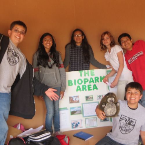 Six students excitedly present a poster that shows their research at the annual Watershed Congress event.