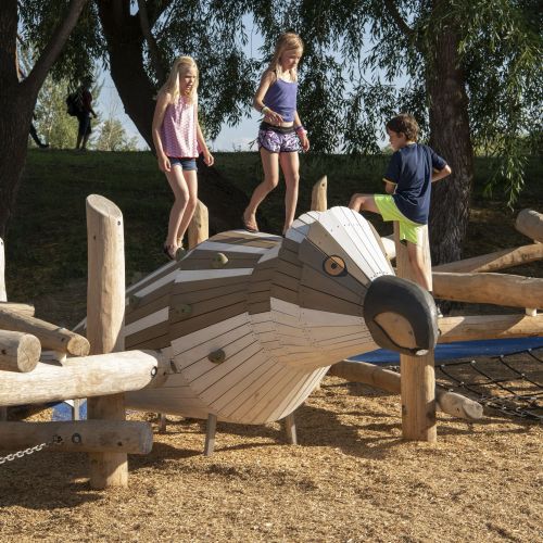 Large wooden bird-shaped play structure with three children standing on it.
