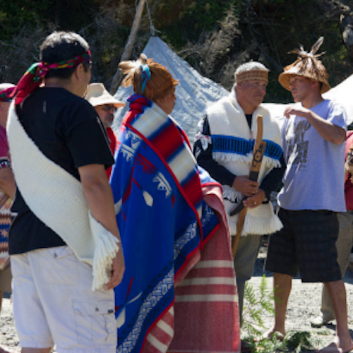 A group of individuals gather wearing traditional clothing.