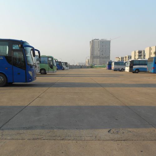 Large paved area with parked buses.