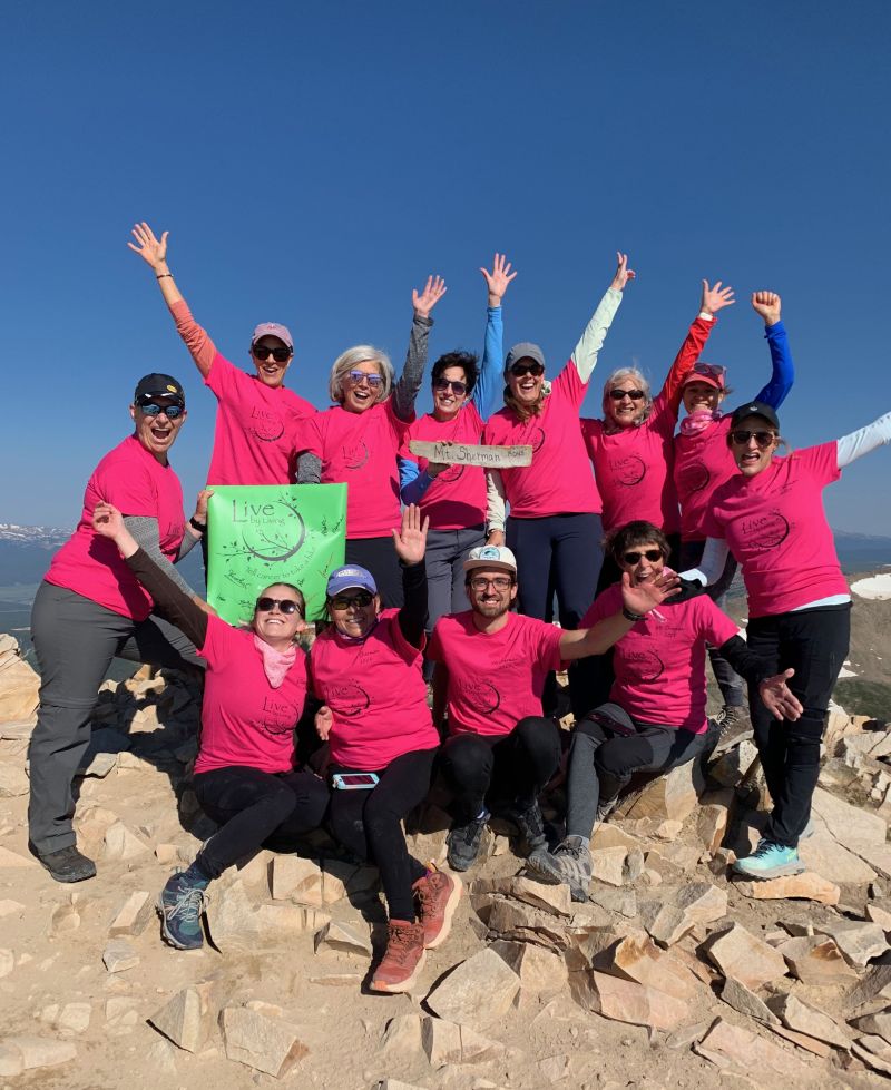 SOCO survivors wearing pink shirts proudly show off their achievement of climbing to the top of Mt. Sherman during a CA to 14k event.